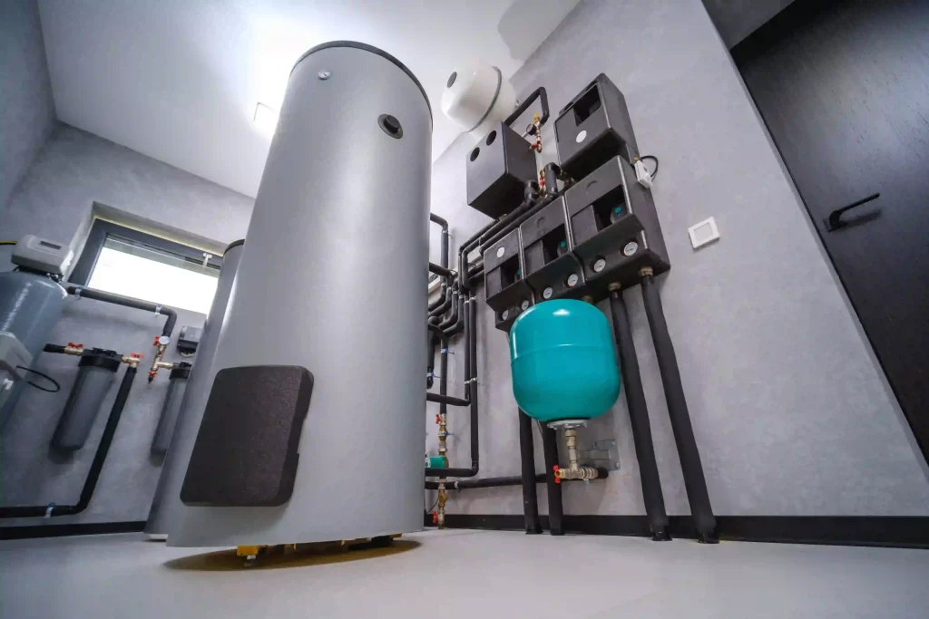 Modern boiler room with a large cylinder, wall-mounted equipment, and interconnected pipes.