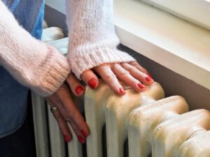 woman touching a central heating radiator