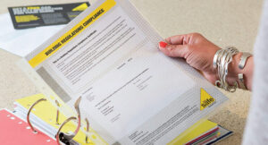 Image of a mature woman holding gas safety documentation